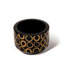 handmade light brown bamboo rings on black wood rounded wine bottle coaster with wine bottle