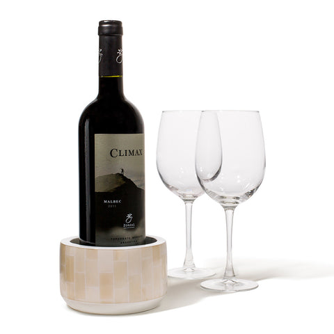 handmade beige rectangular bone arranged vertically on white wood wine bottle coaster with wine bottle inside and two glasses