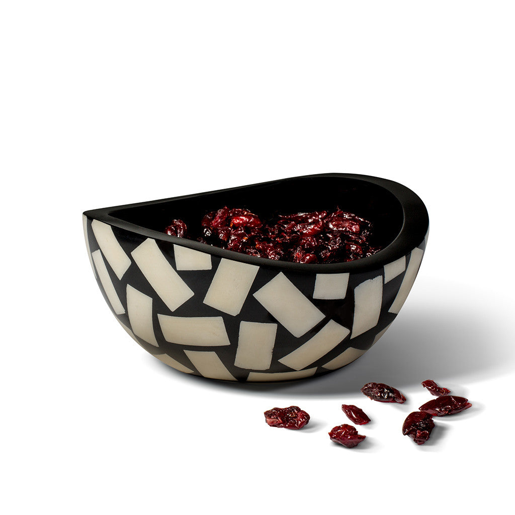 handmade accent bowl black with domino pattern of bone containing dried cranberries