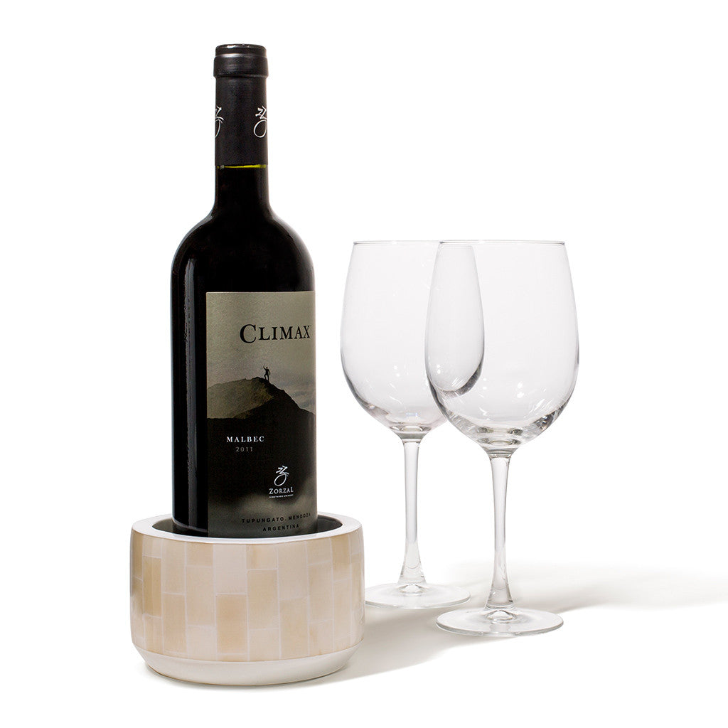 handmade beige rectangular bone arranged vertically on white wood wine bottle coaster with wine bottle inside and two glasses