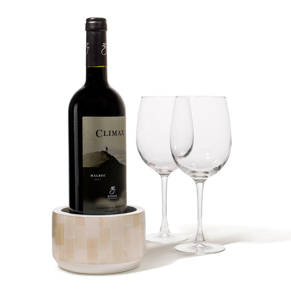 handmade beige rectangular bone arranged vertically on white wood wine bottle coaster with wine bottle inside and two glasses