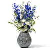 handmade large black wood flower vase with slanted mouth and cream-colored bone with white and blue flowers inside