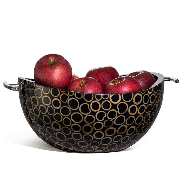 handmade light brown bamboo rings on black serving bowl with black wood interior and silver handles containing red apples 